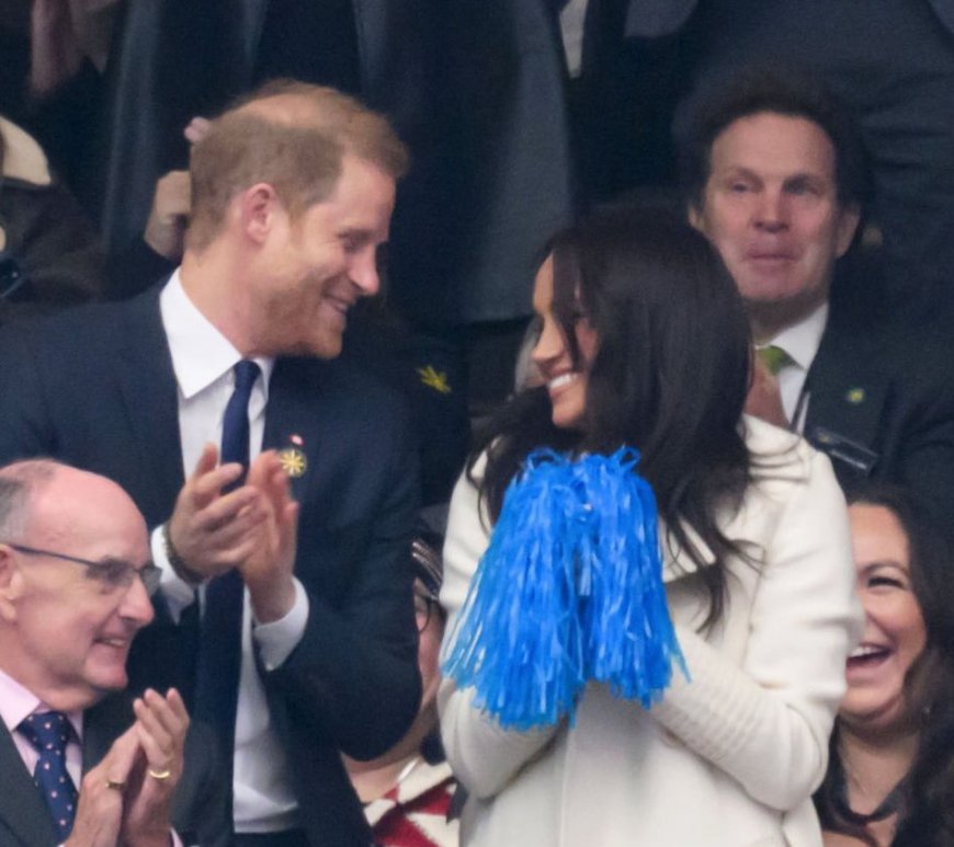 Prince Harry and Meghan Markle smiling and interacting with athletes at the Invictus Games 2025, showcasing warmth and happiness.