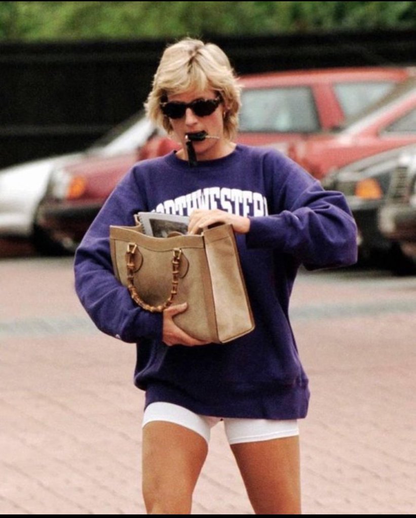 A screenshot of Meghan Markle’s Instagram story shows her wearing a purple Northwestern University sweatshirt outdoors in bright sunlight. She is smiling, partially obscured by the glare, with palm trees visible in the background.